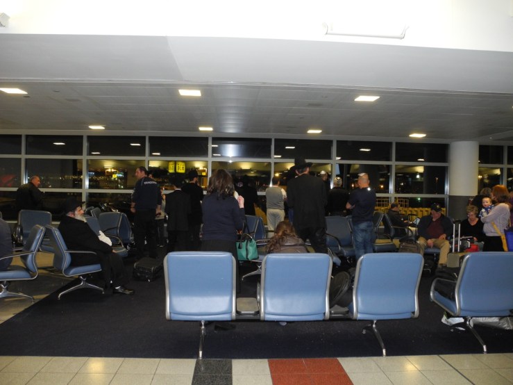 People praying in the boarding area by the windows.