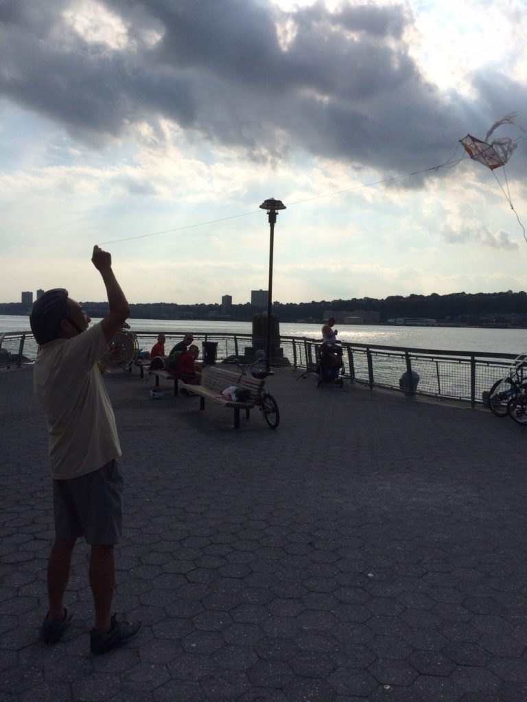 Chinese man flying a homemade kite.