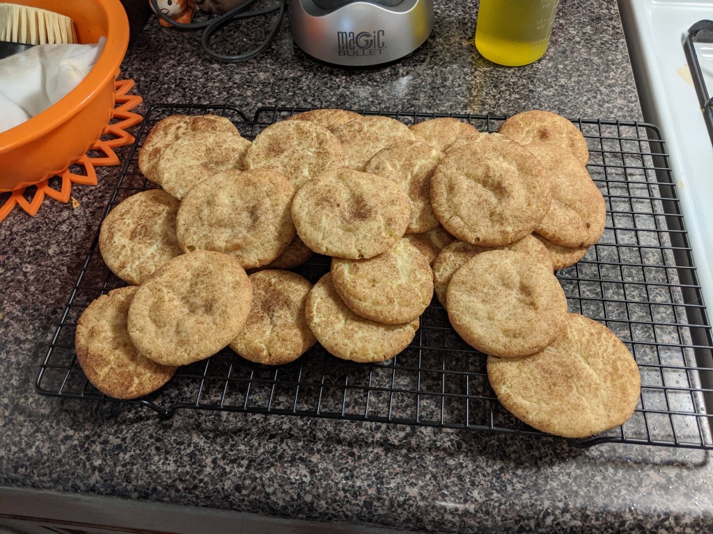 Fresh snickerdoodles cooling on a rack.